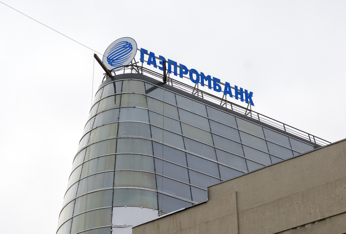Novosibirsk, Novosibirsk region, RF - April 9, 2015: The Russian letters of the name Gazprombank are located on the roof of a glazed modern building against a cloudy sky.
