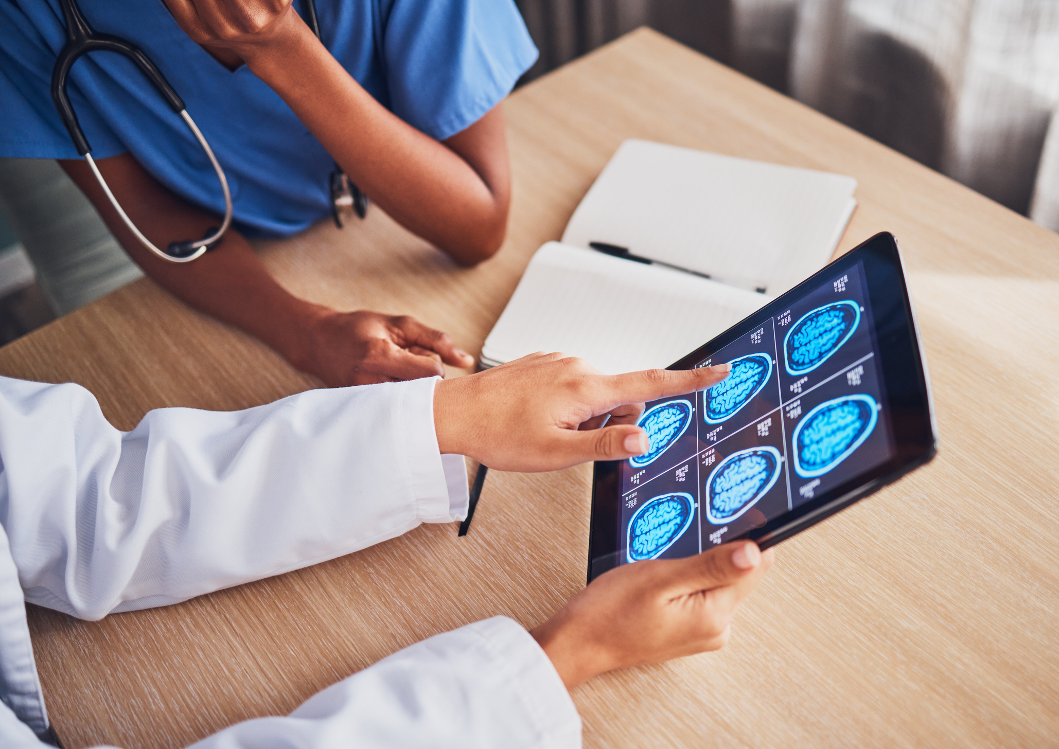 Doctor, tablet and brain xray, neurology and digital test results, people and healthcare team in hospital. MRI, technology and screen in hands, cancer and radiology, anatomy and health assessment