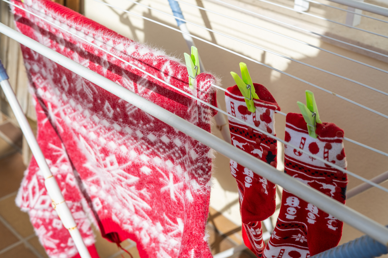 Close Up Sun-Dried Christmas Clothes. Red Sweater And Socks Hanging Outdoors On A Clothesline.Clean Clothes