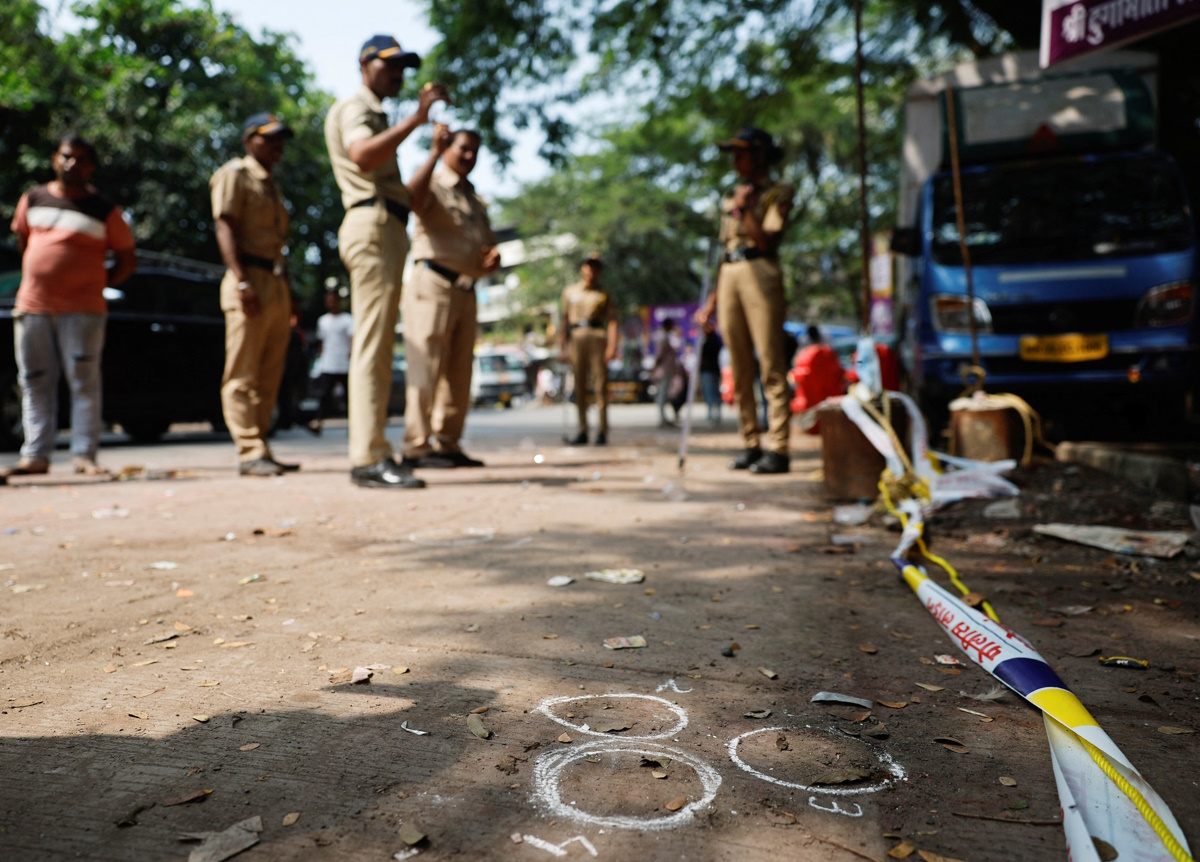 Police officers stand at the crime scene next to markings of the gunshots where Nationalist Congress Party (NCP) politician Baba Siddique was shot dead in Mumbai, India, October 13, 2024. REUTERS