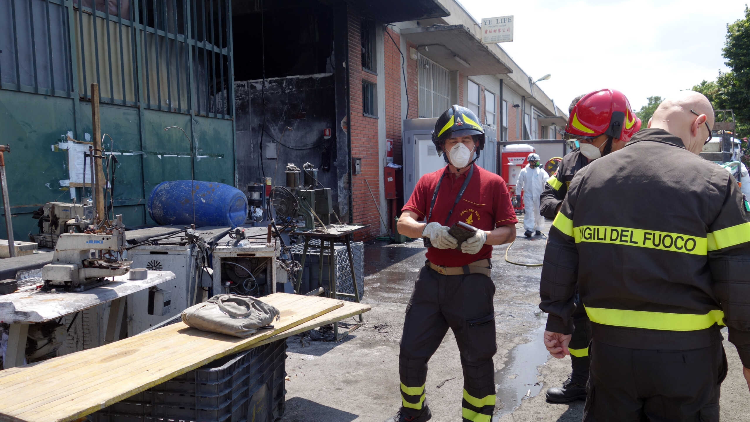 In this June 20, 2014 photo, firemen inspect the burned Teresa Moda garment factory in Prato, Italy. The fire that destroyed the Teresa Moda factory on Dec. 1, 2013, was the deadliest in living memory. It exposed the true cost of cheap clothes, laying bare the consequences of years of failed law enforcement and the pursuit of profit over safety. (AP Photo