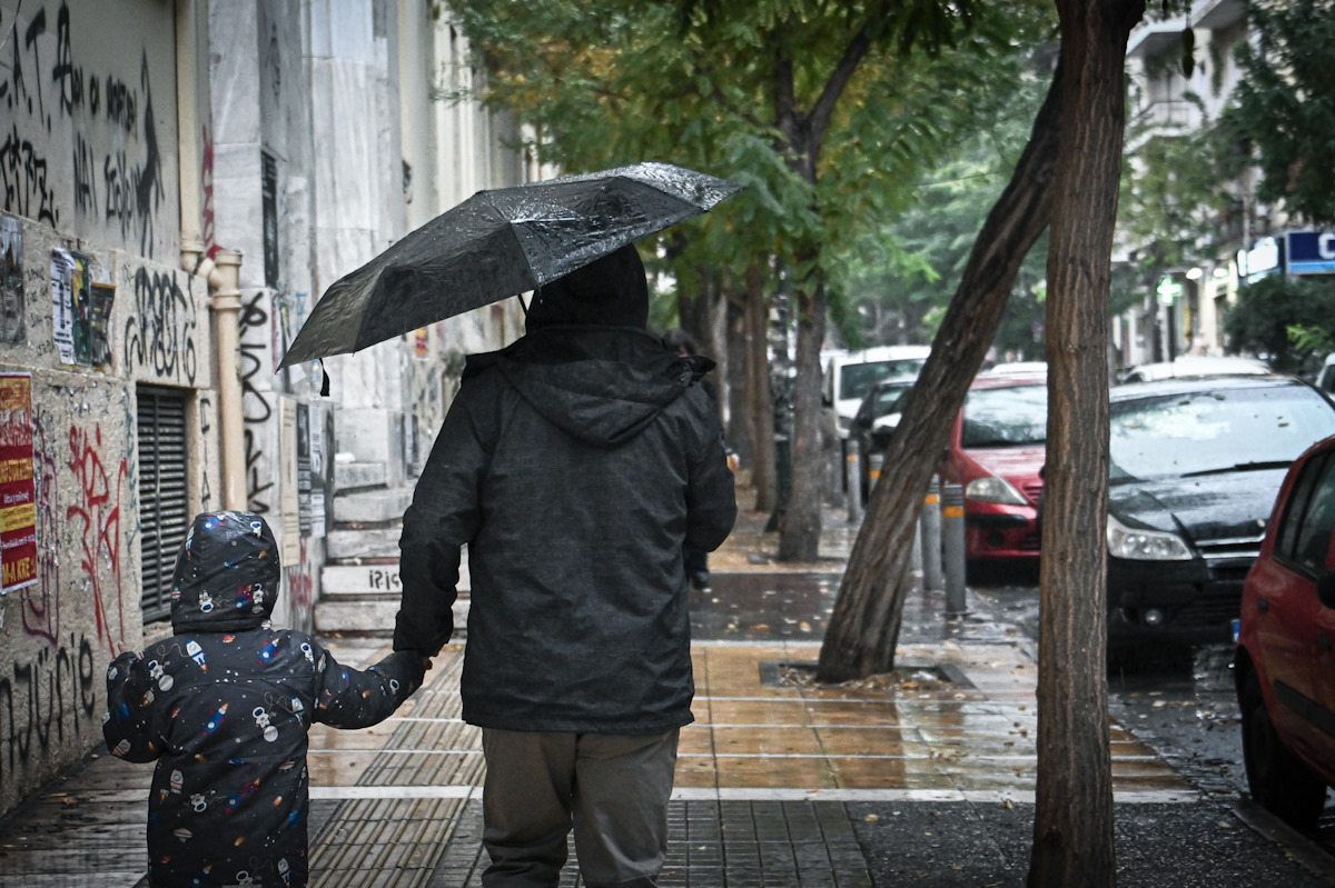 Κόσμος περπατά κρατώντας ομπρέλες, σε διάβαση στο κέντρο της Αθήνας, κατά την διάρκεια βροχόπτωσης, Παρασκευή 15 Νοεμβρίου 2024. (ΚΩΣΤΑΣ ΤΖΟΥΜΑΣ