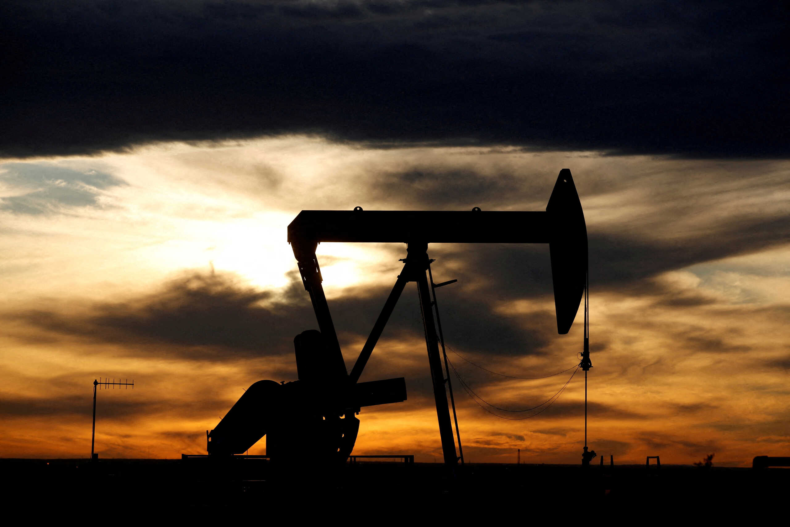 FILE PHOTO: The sun sets behind a crude oil pump jack on a drill pad in the Permian Basin in Loving County, Texas, U.S. November 24, 2019. REUTERS
