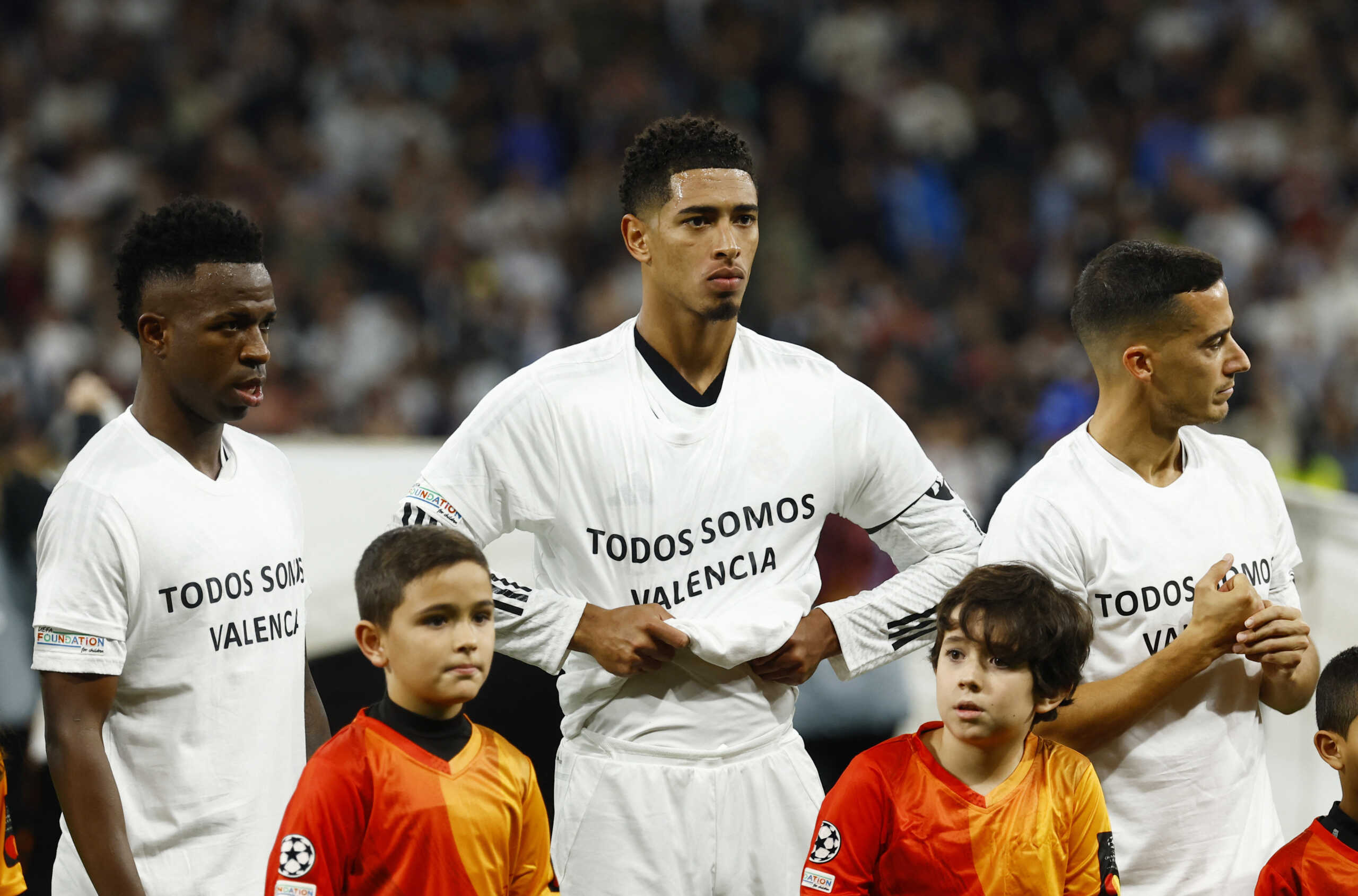 Soccer Football - Champions League - Real Madrid v AC Milan - Santiago Bernabeu, Madrid, Spain - November 5, 2024 Real Madrid's Vinicius Junior, Jude Bellingham and Lucas Vazquez wear a message on their shirt in memory of the flood victims in Valencia before the match REUTERS