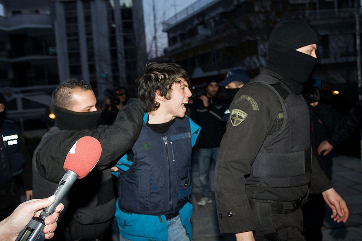 Φωτογραφία αρχείου την 2 Φεβρουαρίου 2013 από την μεταφορά του Ρωμανού Νικόλαου , στον εισαγγελέα Πλημμελειοδικών Κοζάνης προκειμένου να του απαγγελθούν οι κατηγορίες για τη συμμετοχή του στις δύο ένοπλες ληστείες στο Βελβεντό Κοζάνης. Ο φυλακισμένος Νίκος Ρωμανός, ο οποίος κατηγορείται για τη συμμετοχή του στη ληστεία στο Βελβεντό Κοζάνης, πραγματοποιεί απεργία πείνας για 30η μέρα, διεκδικώντας το δικαίωμα να λαμβάνει άδειες, προκειμένου να παρακολουθεί το πρόγραμμα πανεπιστημιακής σχολής στην Αθήνα, στην οποία έχει περάσει έπειτα από πανελλήνιες εξετάσεις την περασμένη άνοιξη, Τρίτη 9 Δεκεμβρίου 2014.   ΑΠΕ-ΜΠΕ