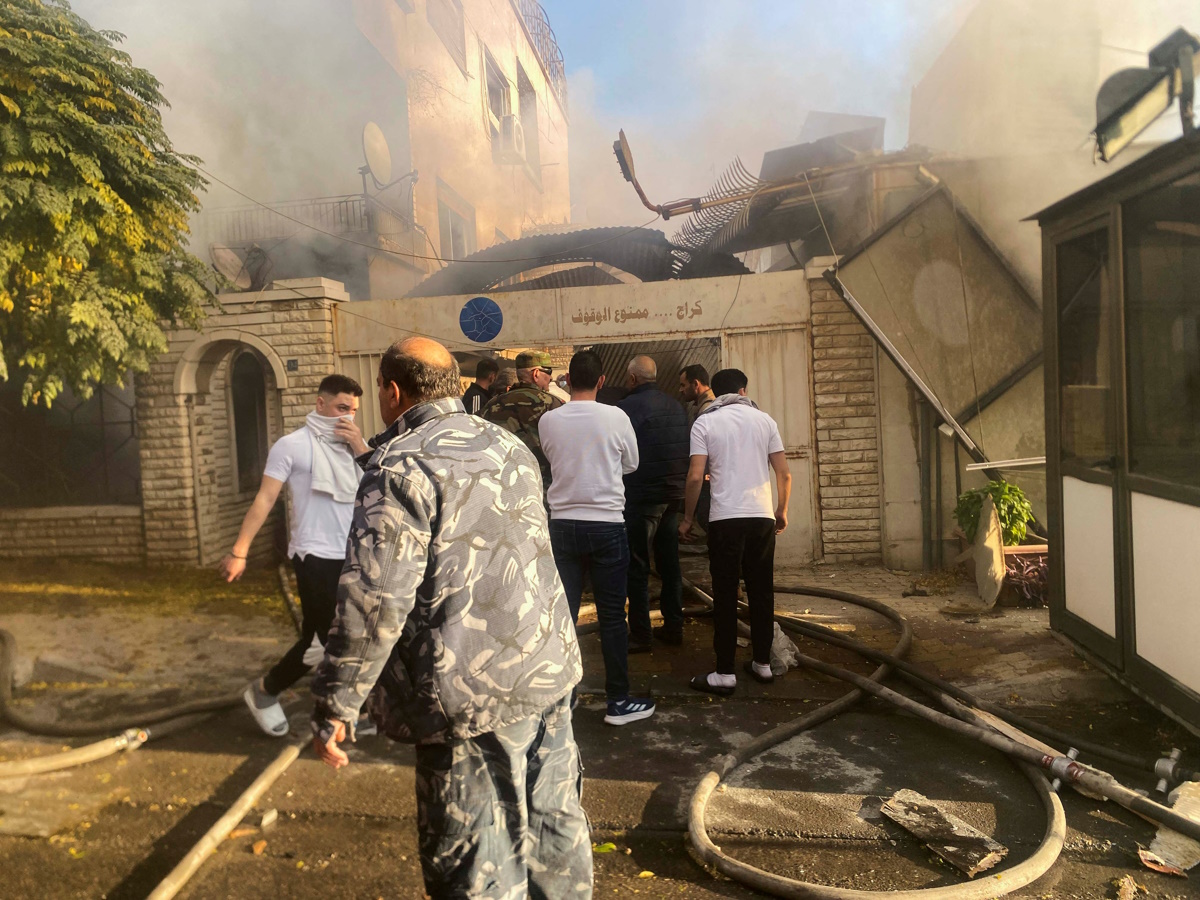 Smoke rises as people gather at a damaged site after what a Syrian state news agency said was an Israeli strike in the Damascus suburb of Mazzeh, Syria November 14, 2024. REUTERS