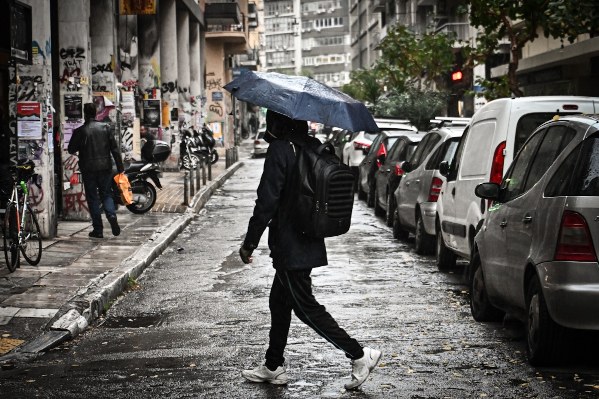 Κόσμος περπατά κρατώντας ομπρέλες, σε διάβαση στο κέντρο της Αθήνας, κατά την διάρκεια βροχόπτωσης, Παρασκευή 15 Νοεμβρίου 2024. (ΚΩΣΤΑΣ ΤΖΟΥΜΑΣ