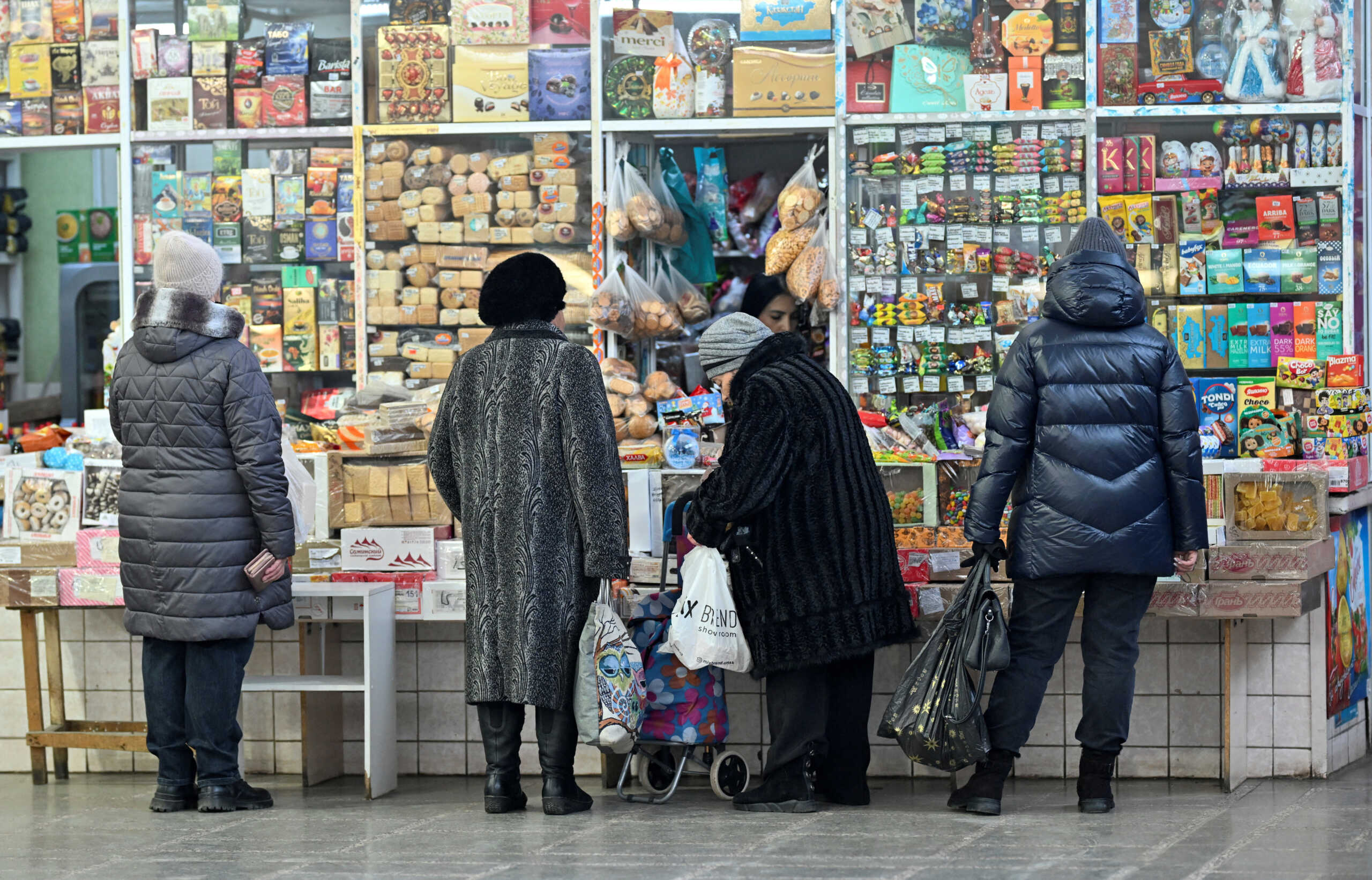 Customers wait in line outside a kiosk at a food market in the Siberian city of Omsk, Russia, November 29, 2024. REUTERS