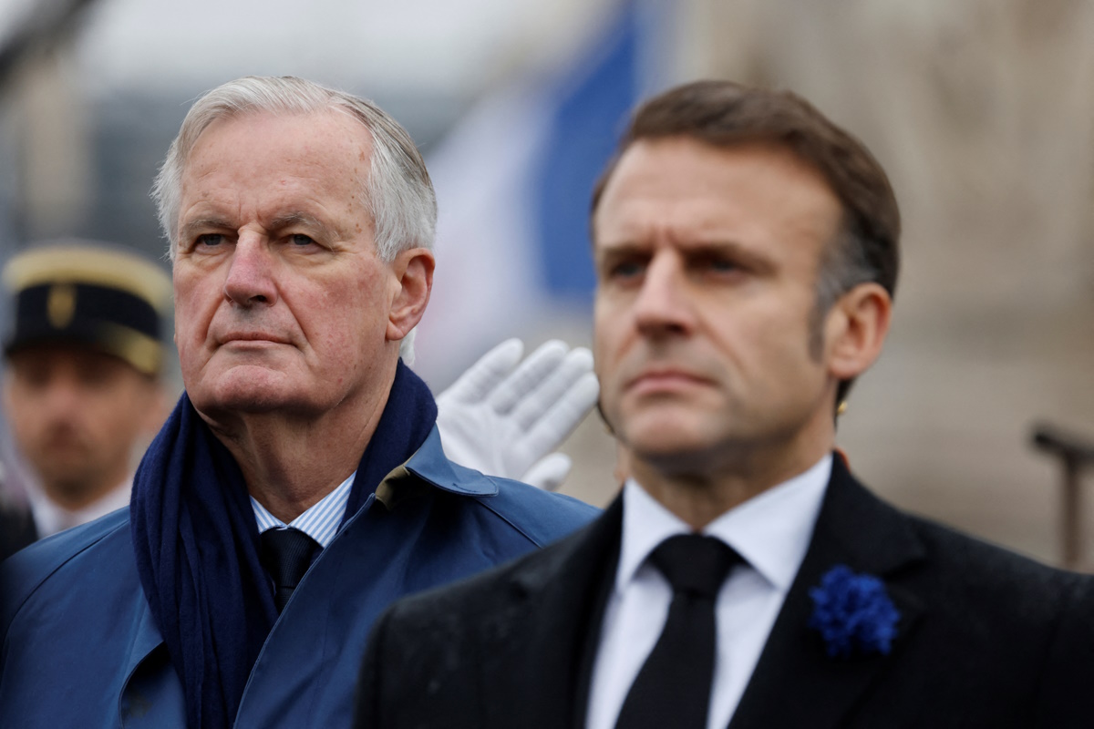 France's President Emmanuel Macron and France's Prime Minister Michel Barnier stand at attention during commemorations marking the 106th anniversary of the November 11, 1918, Armistice, ending World War I (WWI), in Paris, on November 11, 2024. LUDOVIC MARIN