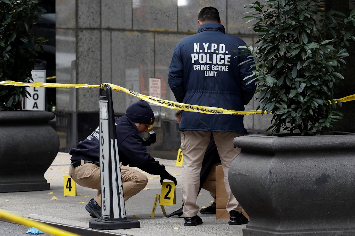 Members of the NYPD Crime Scene Unit work near evidence markers placed where shell casings were found at the scene where the CEO of UnitedHealthcare Brian Thompson was reportedly shot and killed in Midtown Manhattan, in New York City, US, December 4, 2024.REUTERS