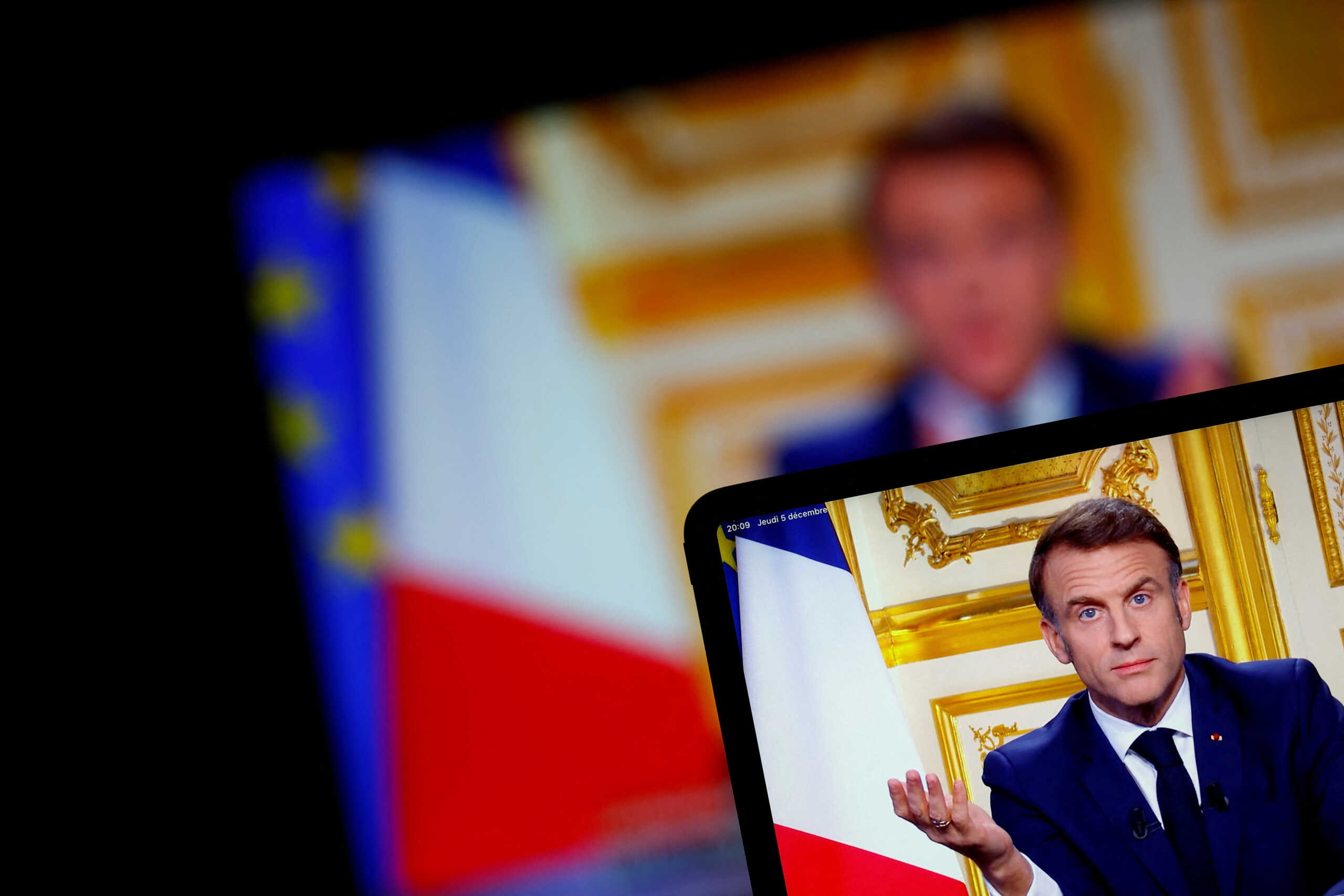 French President Emmanuel Macron appears on screen as he makes a television address to the nation after Prime Minister Michel Barnier's government was toppled in a no confidence vote in parliament, in Paris, France, December 5, 2024. REUTERS