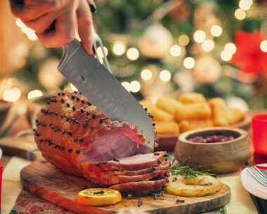 Woman carving glazed ham for holiday dinner