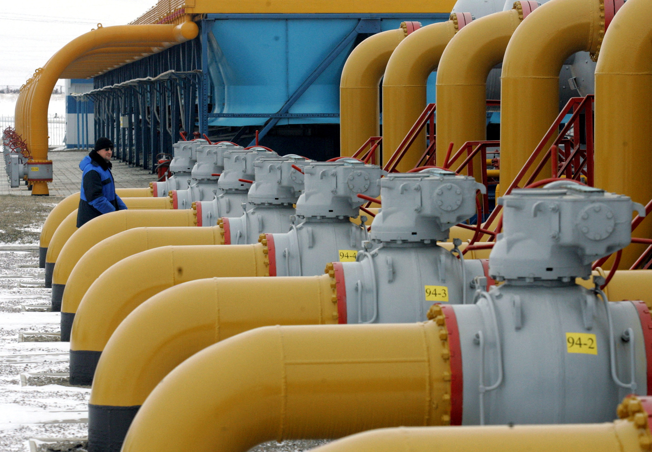FILE PHOTO: A gas worker walks between pipes in a compressor and distribution station of the Urengoy-Pomary-Uzhgorod gas pipeline, some 30 km (19 miles) from the south western Russian city of Kursk January 4, 2006. REUTERS