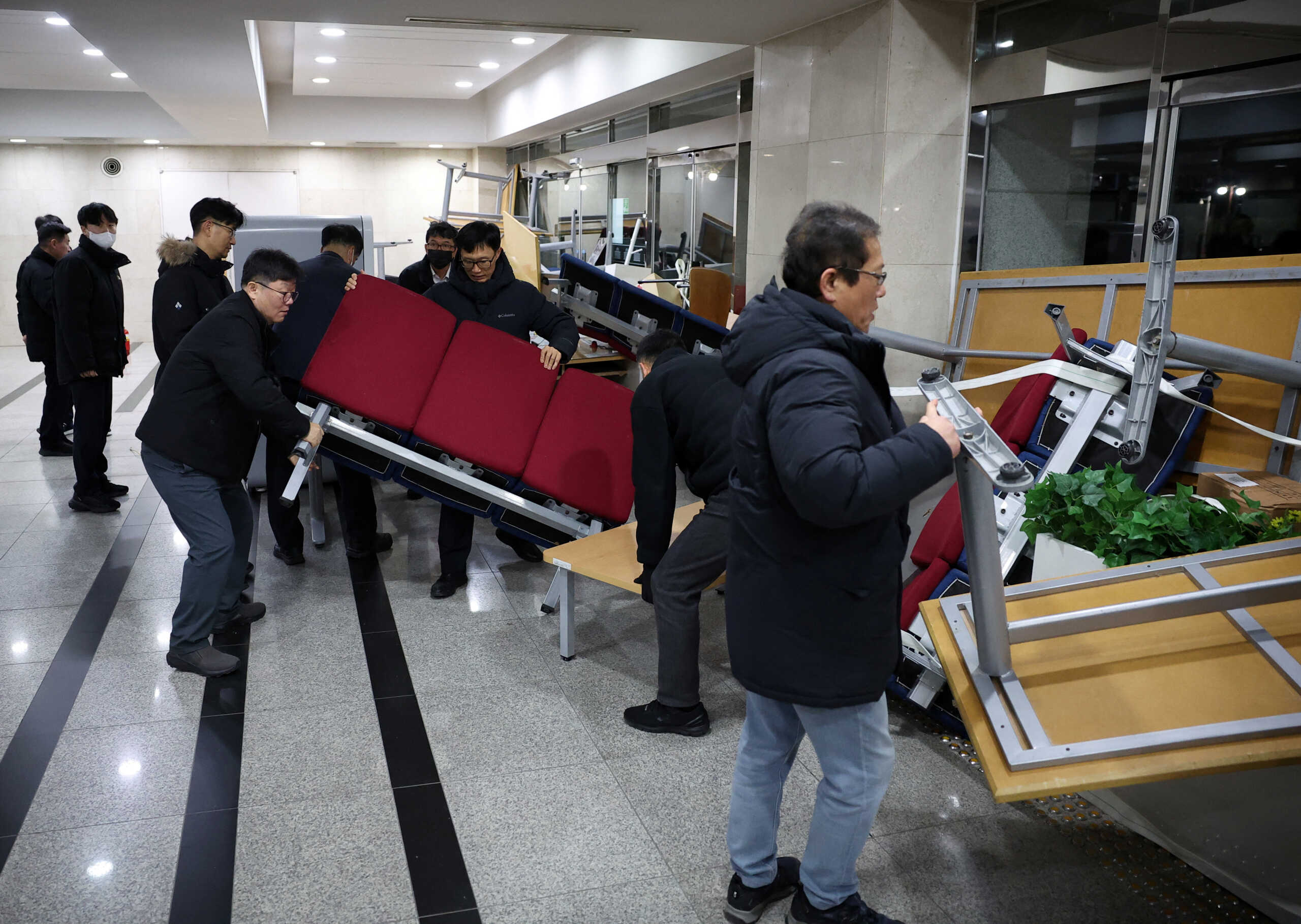 Officials remove the furniture barricades from the doors of the National Assembly building, after South Korean President Yoon Suk Yeol declared martial law, in Seoul, South Korea, December 4, 2024. REUTERS