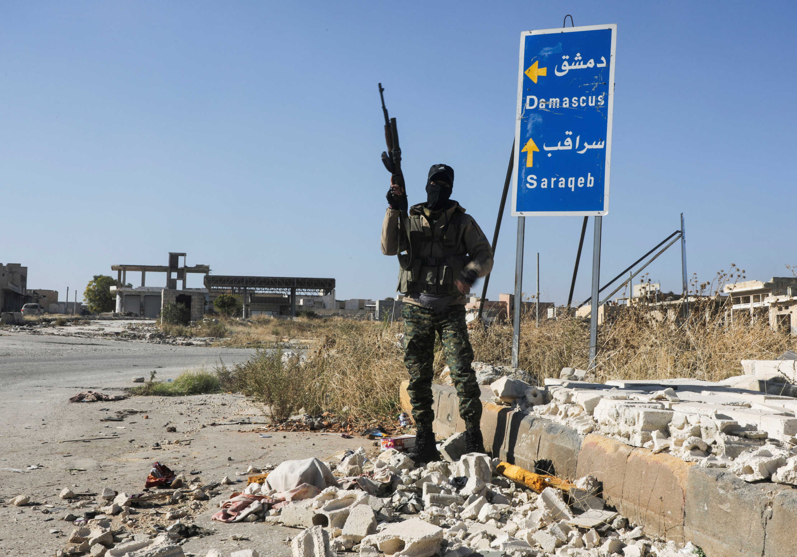 A rebel fighter carries a weapon as he stands at the entrance of Saraqeb town in northwestern Idlib province, Syria December 1, 2024. REUTERS