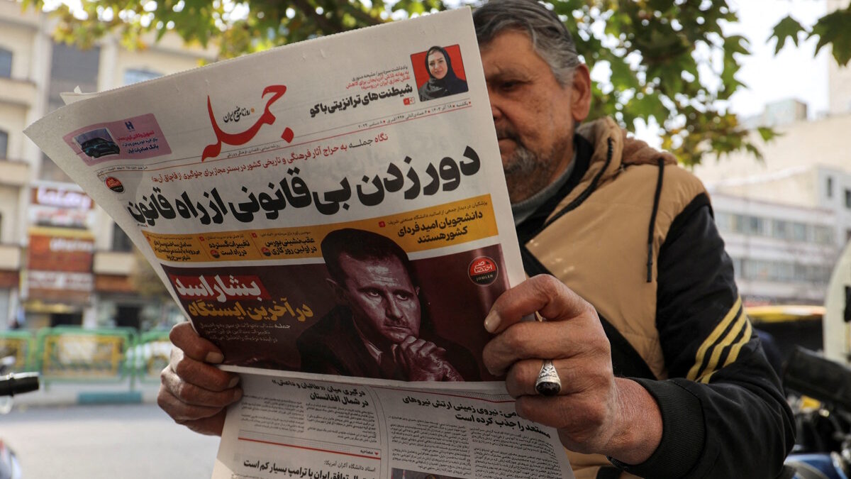FILE PHOTO: An Iranian man reads a newspaper with a picture of Syrian President Bashar al-Assad in Tehran, Iran December 8, 2024. Majid Asgaripour