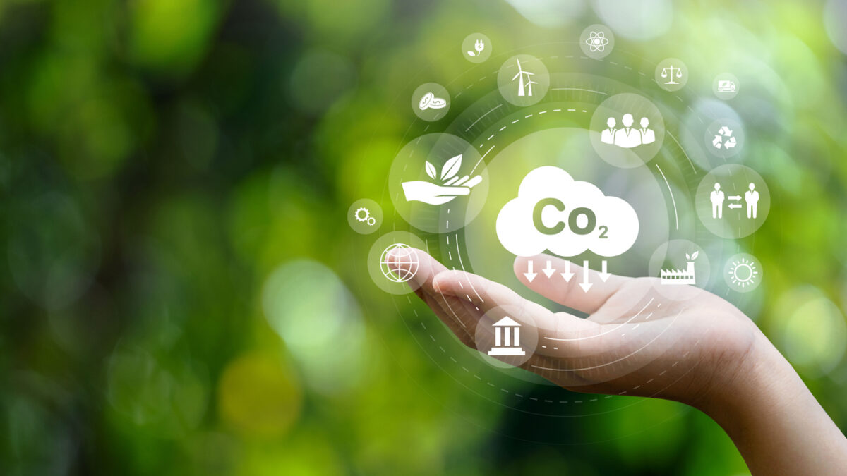 CO2 emission reduction concept in hand with environmental icons, global warming, sustainable development, connectivity and renewable energy