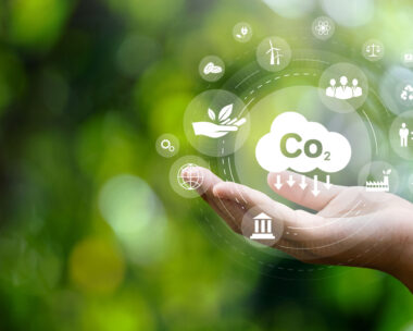 CO2 emission reduction concept in hand with environmental icons, global warming, sustainable development, connectivity and renewable energy