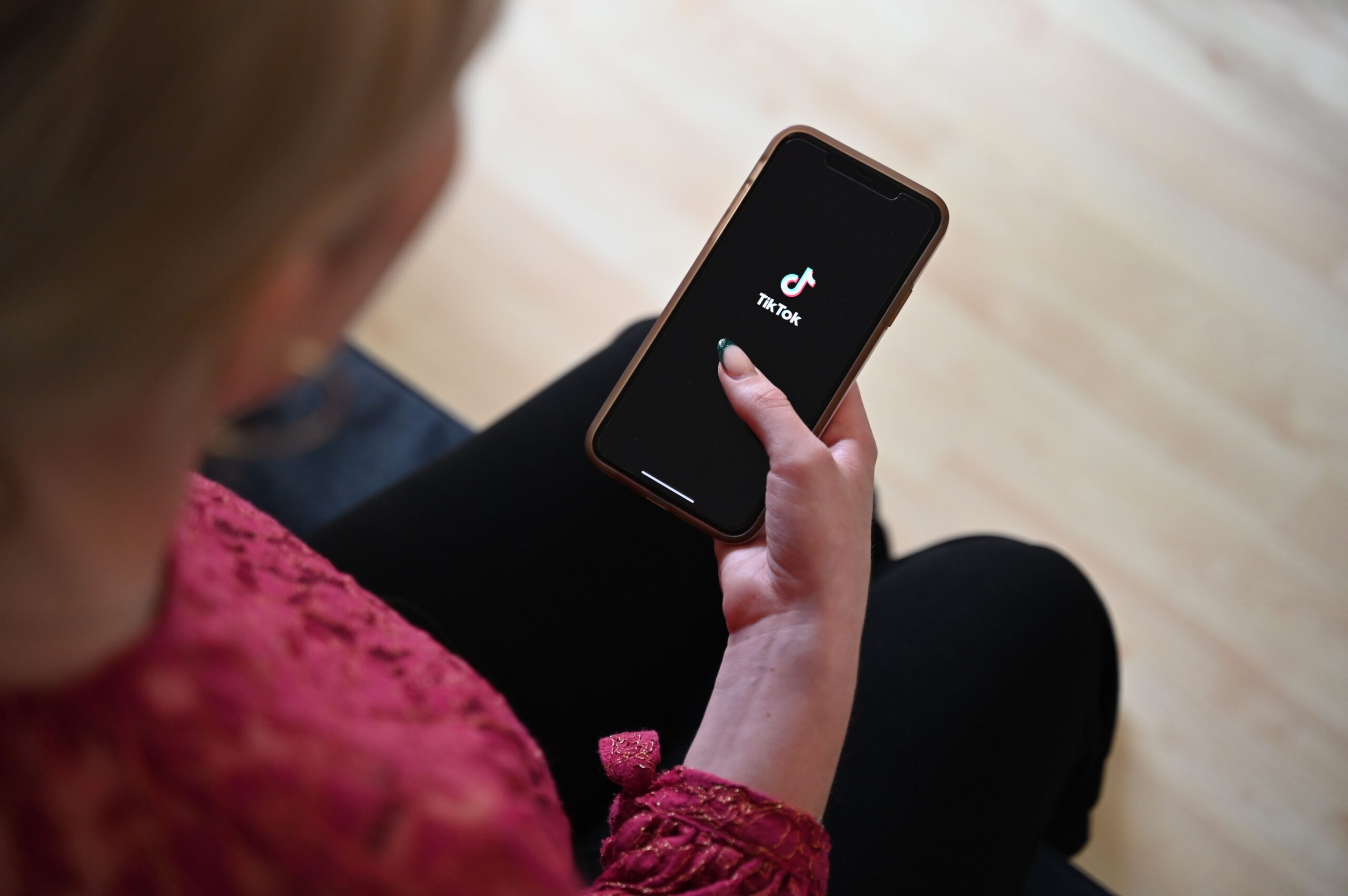 Γυναίκα ανοίγει το TikTok στο smartphone της - Photo: Helena Dolderer