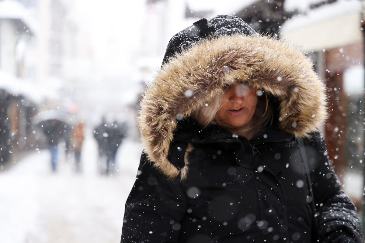 A woman walks on the street during snowstorm in Sarajevo, Bosnia and Herzegovina, December 24, 2024.REUTERS