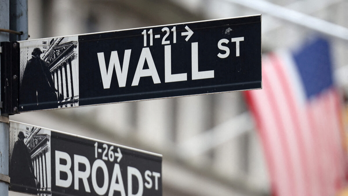 FILE PHOTO: A Wall Street sign hangs in front of a U.S. Flag outside the New York Stock Exchange (NYSE) before the Federal Reserve announcement in New York City, U.S., September 18, 2024. REUTERS