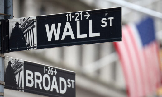 FILE PHOTO: A Wall Street sign hangs in front of a U.S. Flag outside the New York Stock Exchange (NYSE) before the Federal Reserve announcement in New York City, U.S., September 18, 2024. REUTERS