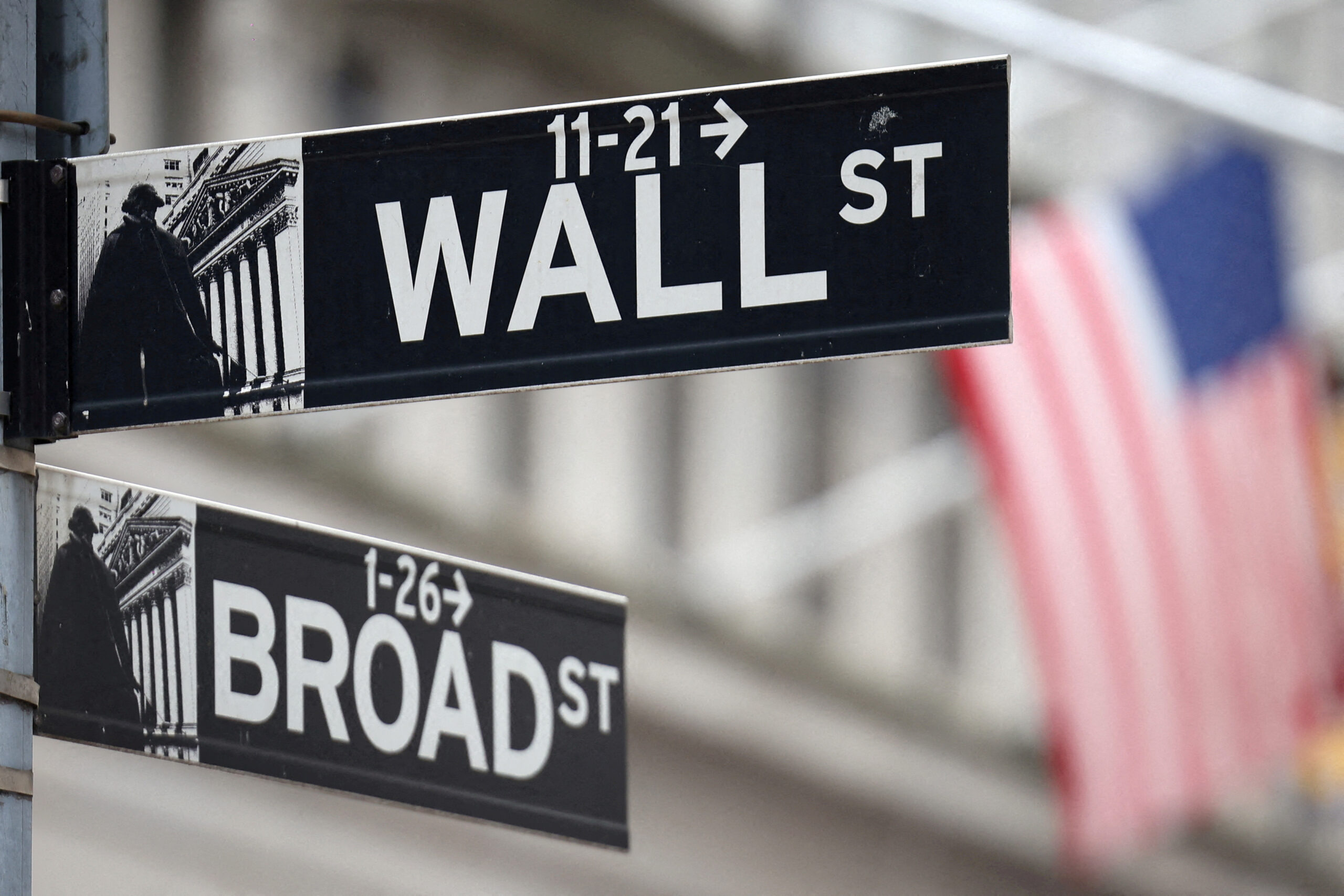 FILE PHOTO: A Wall Street sign hangs in front of a U.S. Flag outside the New York Stock Exchange (NYSE) before the Federal Reserve announcement in New York City, U.S., September 18, 2024. REUTERS