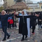 Μασκαράδες χορεύουν στην πλατεία Μοναστηρακίου παραδοσιακούς χορούς