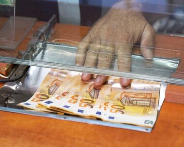 Clerk giving cash money to customer at bank office