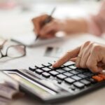 Hands counting finances on a home calculator