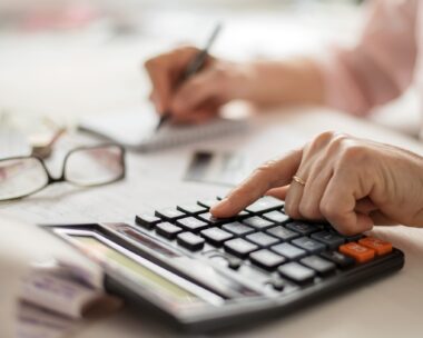 Hands counting finances on a home calculator