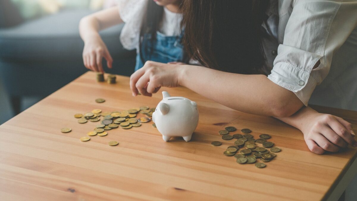 Mother and her daughter count coins from piggy bank