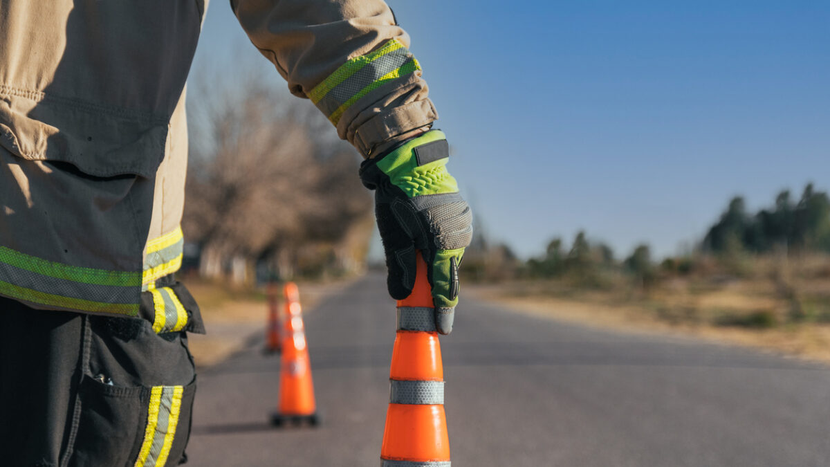 Firefighter putting cone on road