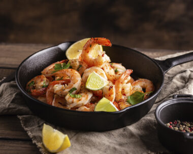 Grilled shrimps with greens and garlic in a pan