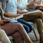 business people sitting on chairs in waiting room