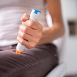 Auto Epinephrine Injector. Patient Doing Leg Injection