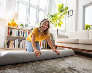 Woman moving house and unrolling a carpet
