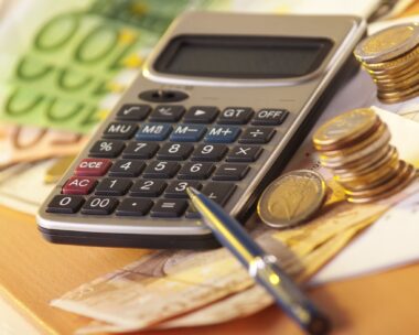 money on a table with calculator and coins
