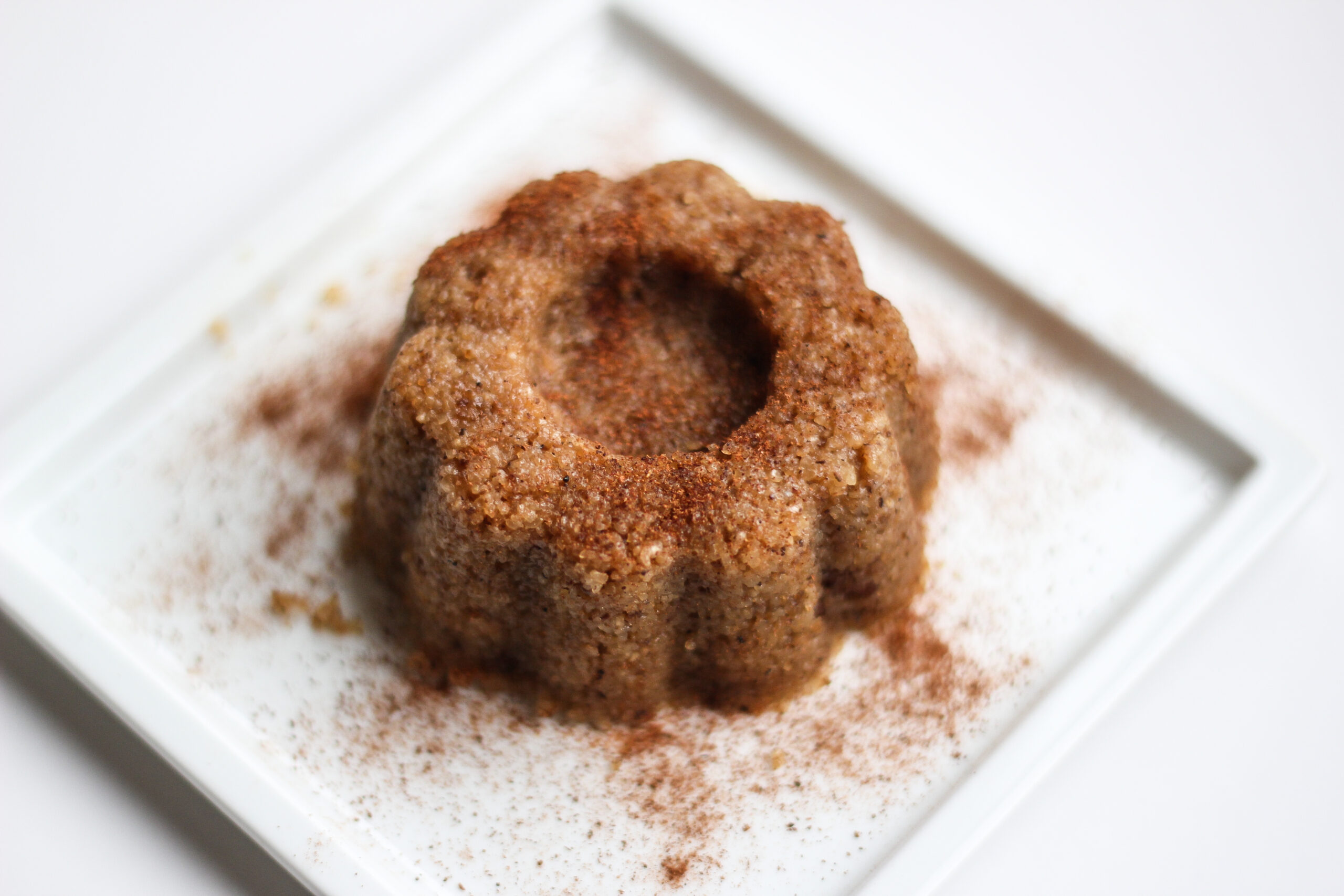 Sweet food, semolina halva on a white plate with white background.