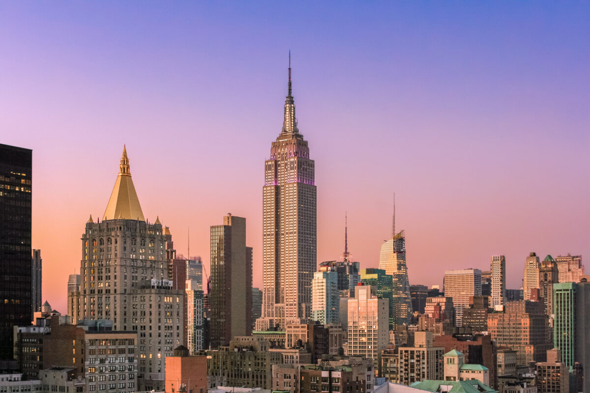New York City Skyline at Sunset with Empire State Building, Midtown Manhattan Skyscrapers and Clear Sky. Magenta filter