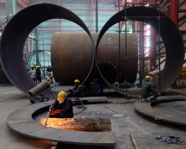 A worker cuts a metal plate inside an industrial tank manufacturing factory on the outskirts of Ahmedabad, India, January 31, 2025. REUTERS