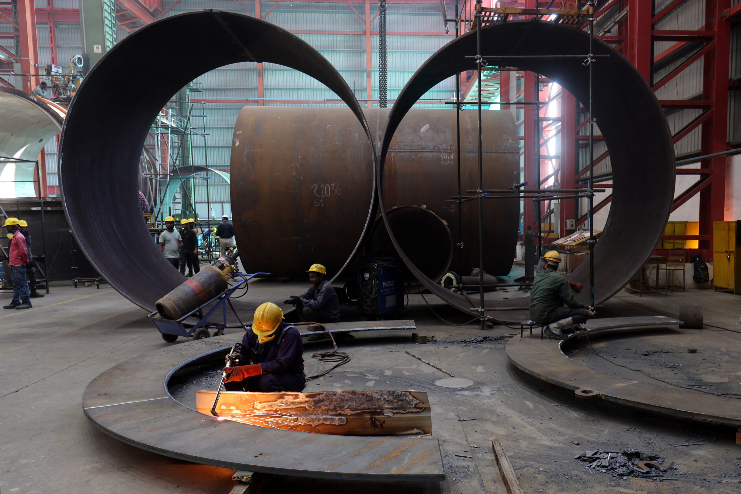 A worker cuts a metal plate inside an industrial tank manufacturing factory on the outskirts of Ahmedabad, India, January 31, 2025. REUTERS