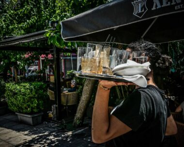 Σερβιτόρος κρατά γεμάτο δίσκο σε κατάστημα εστίασης