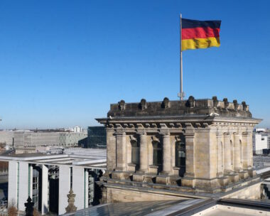 German national flag flutters on top of the Reichstag building