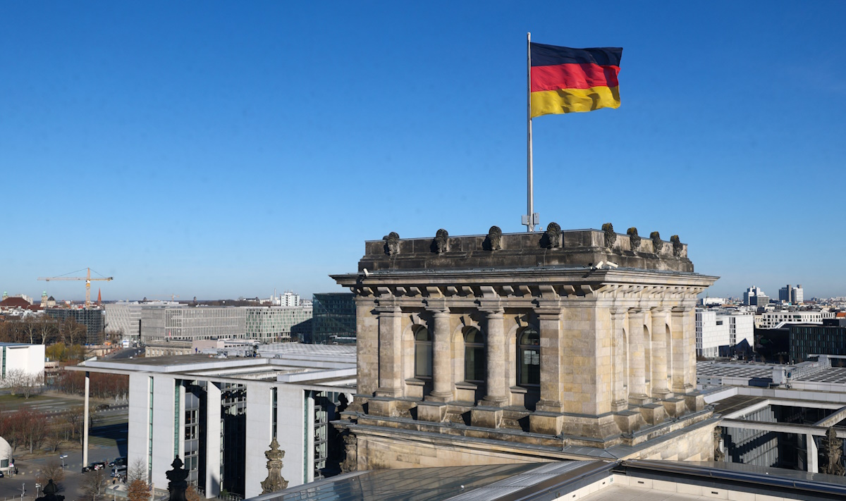German national flag flutters on top of the Reichstag building
