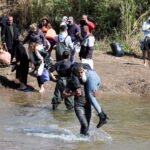 Αλαουίτες Σύροι, που διέφυγαν από τη βία στη δυτική Συρία, περπατούν στο νερό του Nahr El Kabir, μετά τις αναφερόμενες μαζικές δολοφονίες μελών της μειονότητας των Αλαουιτών