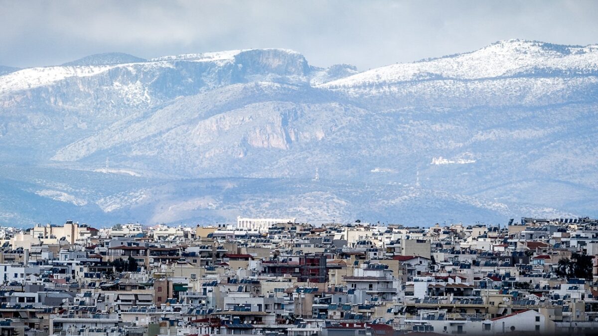 η αθήνα από ψηλά με φόντο την χιονισμένη πάρνηθα