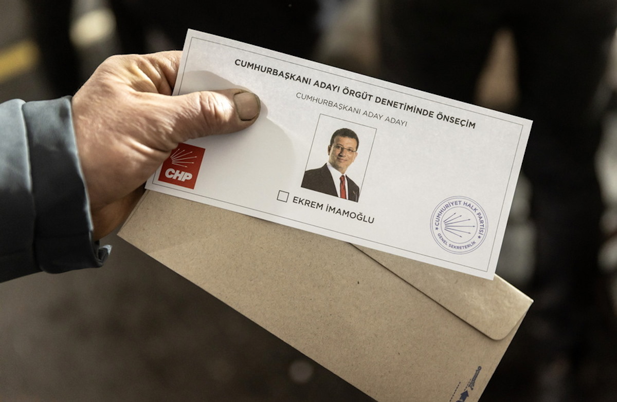 Ένας άνδρας κρατάει το ψηφοδέλτιο με τη φωτογραφία του Εκρέμ Ιμάμογλου