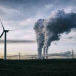 a coal burning power plant with pollution and electricity pylons