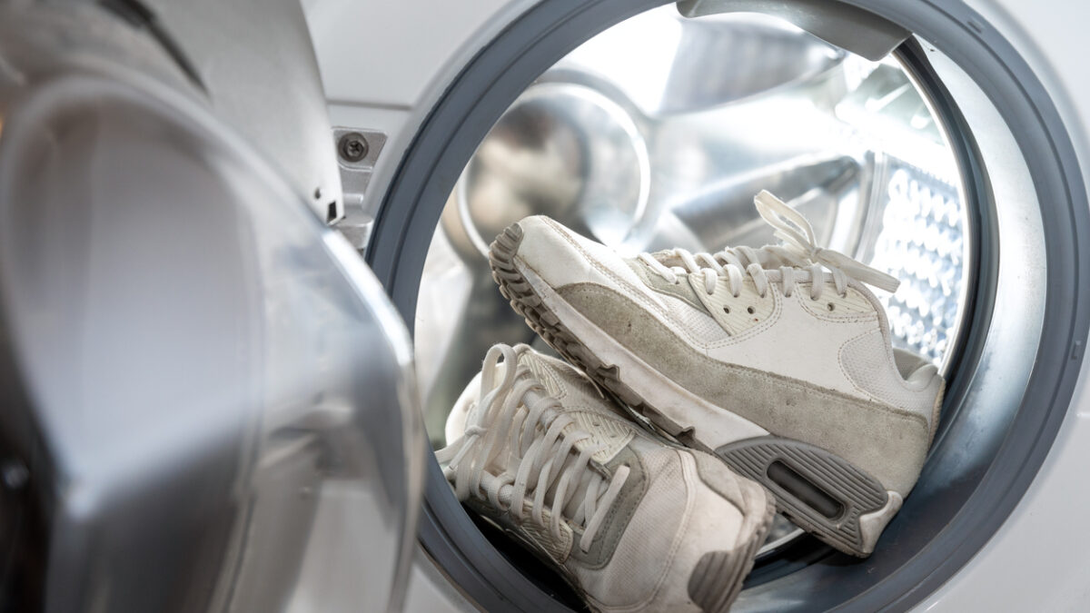 footwear hygiene - pair of dirty white sneakers in the washing machine